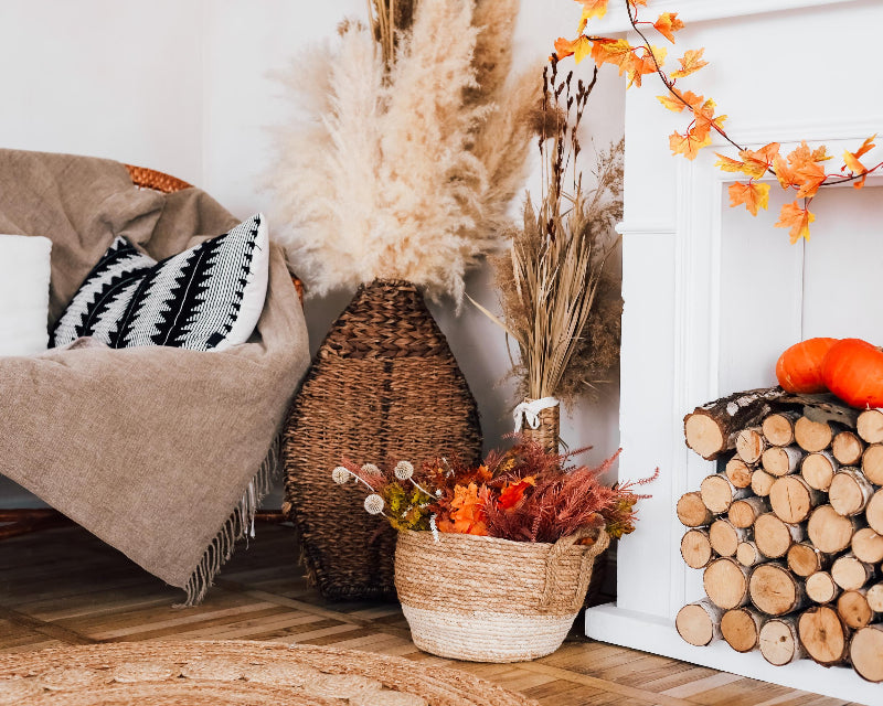 Chair next to a stack of firewood in a sitting room with fall decor around it
