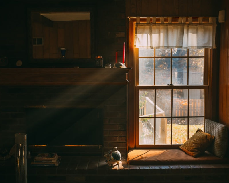dimly lit room with sunlight coming through a window over a sitting area