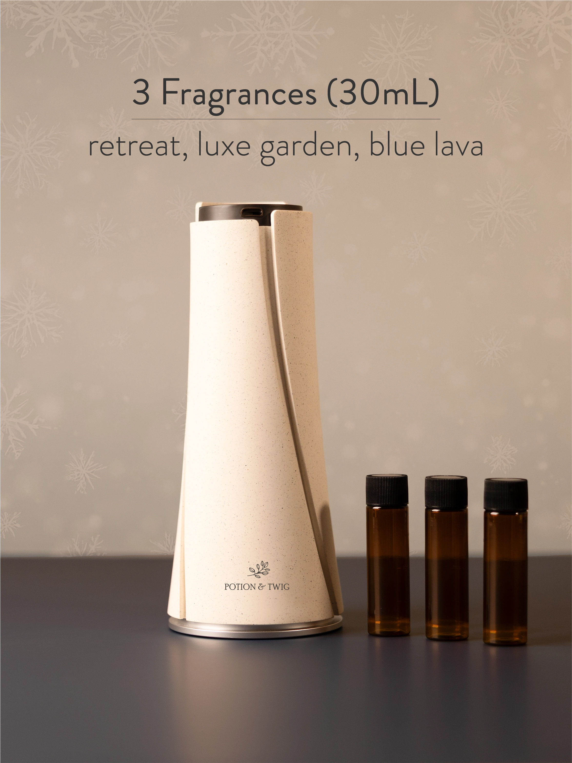 White diffuser with three small brown bottles labeled 'retreat', 'luxe garden', and 'blue lava' on a neutral background.