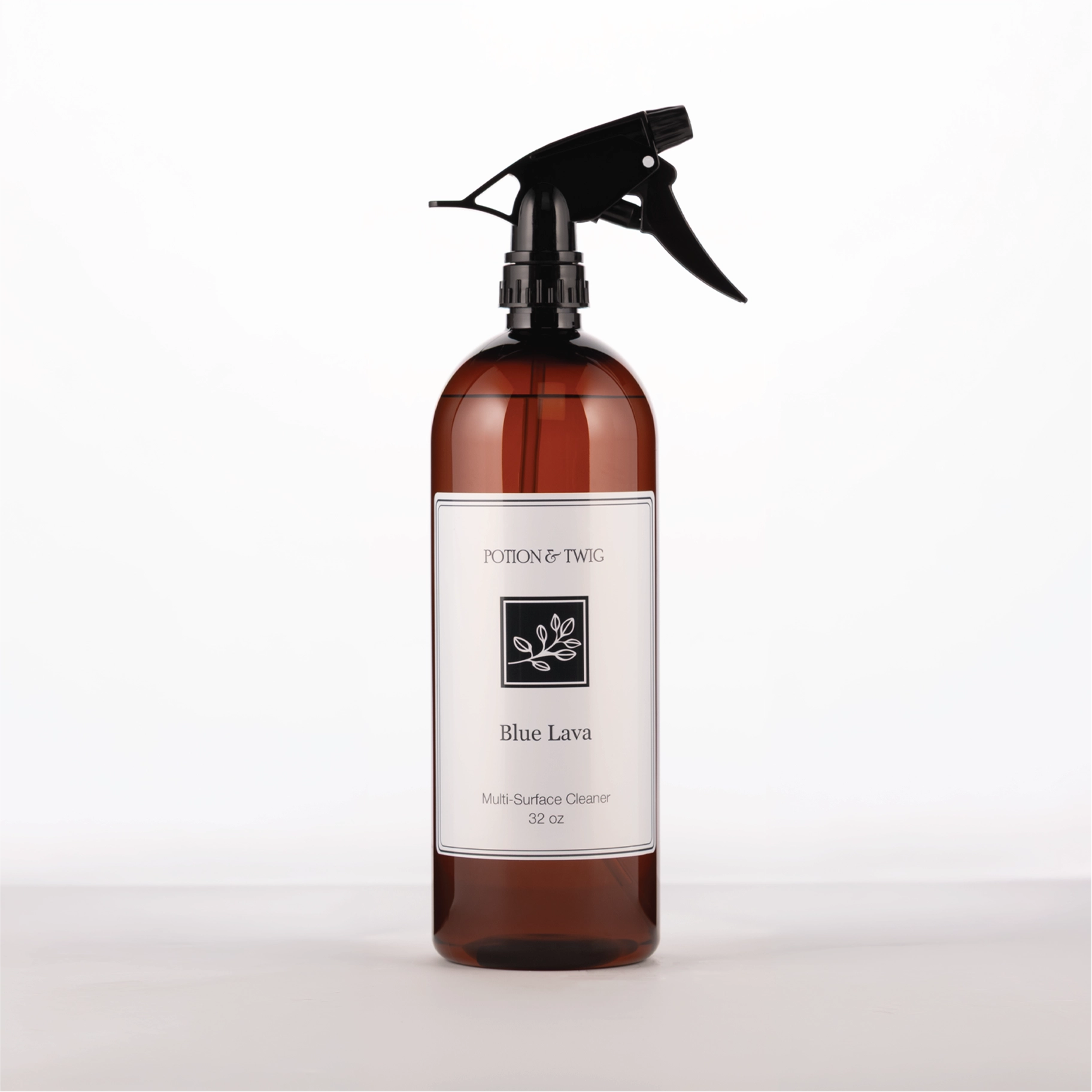 Brown spray bottle with 'Potion & Twig' brand label. On a white background. Labeled Blue Lava Multi-Surface Cleaner