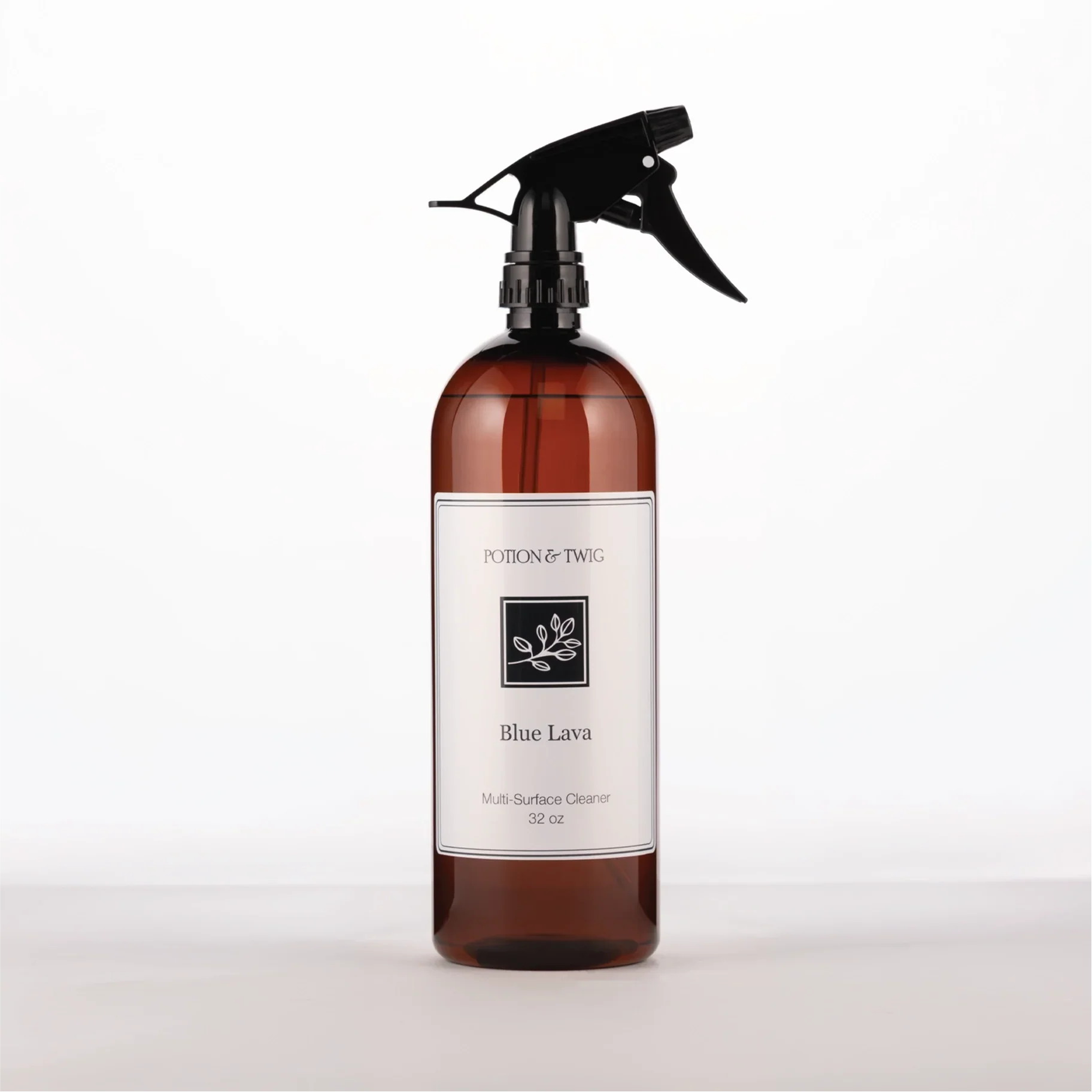 Brown spray bottle with 'Potion & Twig' brand label. On a white background. Labeled Blue Lava Multi-Surface Cleaner