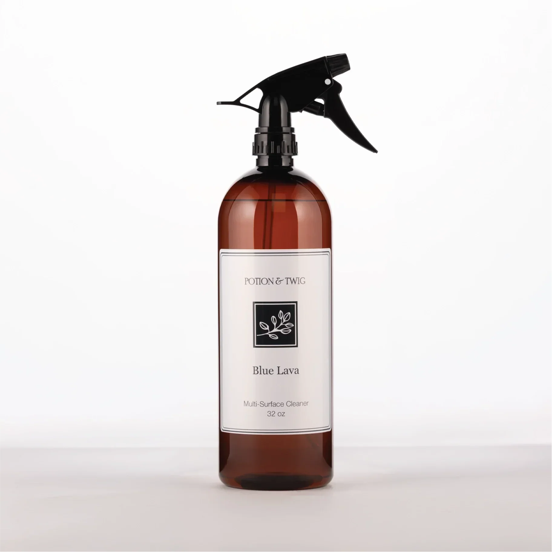 Brown spray bottle with 'Potion & Twig' brand label. On a white background. Labeled Blue Lava Multi-Surface Cleaner
