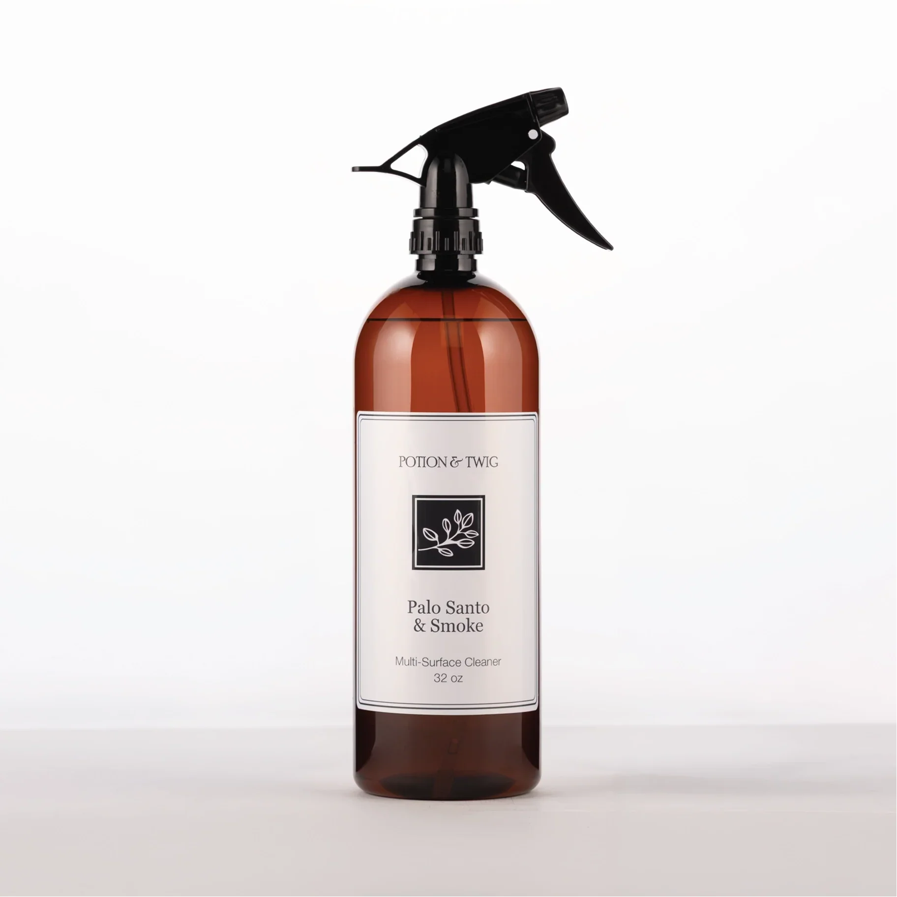 Brown spray bottle with 'Potion & Twig' brand label. On a white background. Labeled Palo Santo & Smoke Multi-Surface Cleaner
