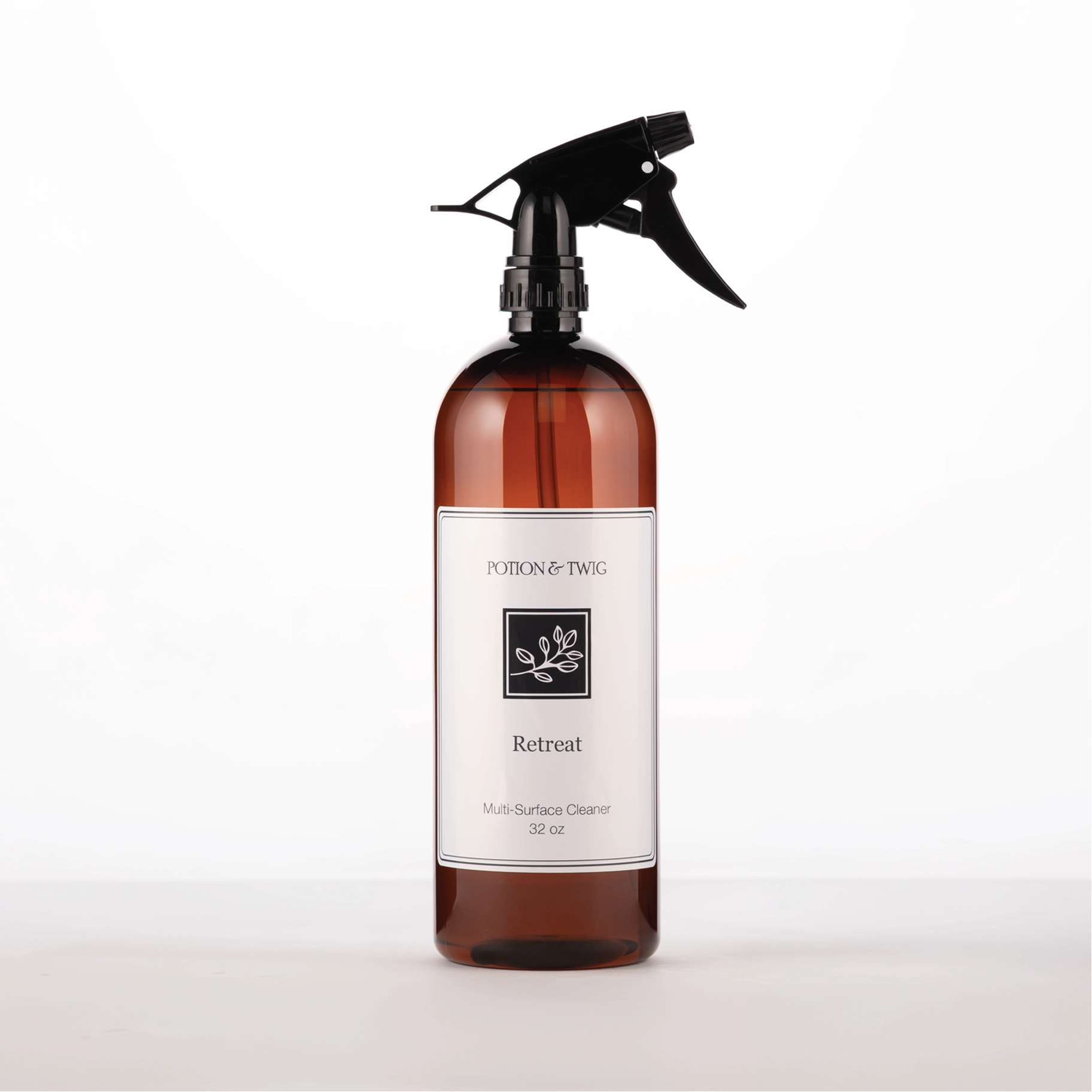Brown spray bottle with 'Potion & Twig' brand label. On a white background. Labeled Retreat Multi-Surface Cleaner