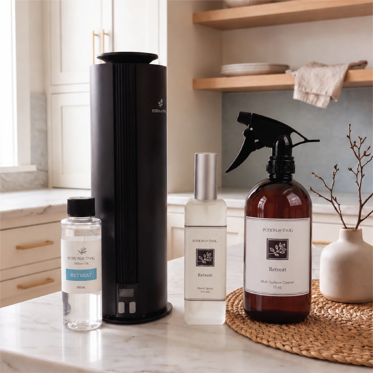 Four Potion & Twig products, featuring a Retreat 16 oz Multi-Surface cleaner, Retreat 130mL room spray, a spire diffuser with a Retreat 100mL oil bottle sitting on a countertop in a kitchen.
