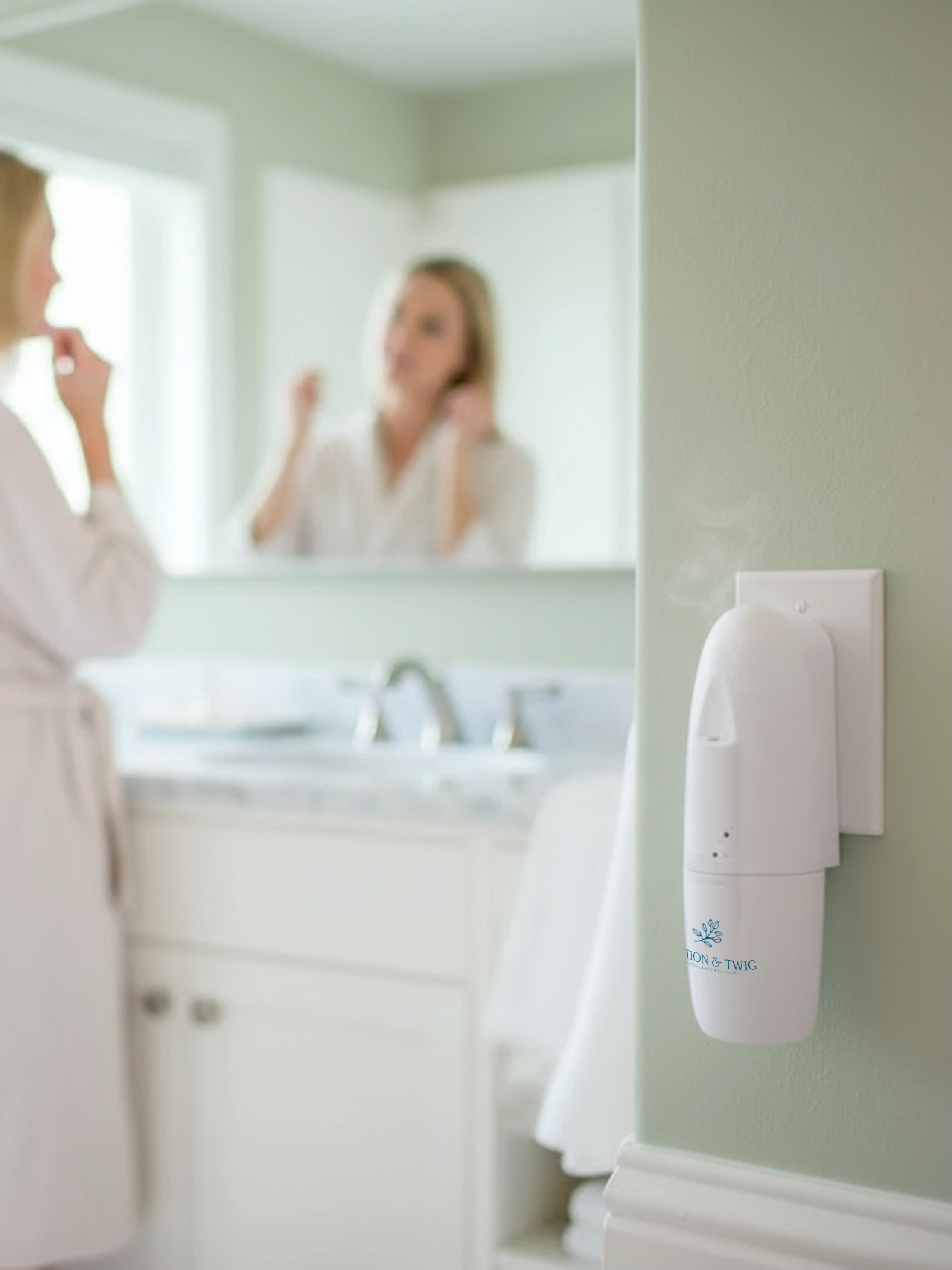 Woman applying cream in front of a mirror with a "Sienna" scent diffuser plugged into the wall outlet