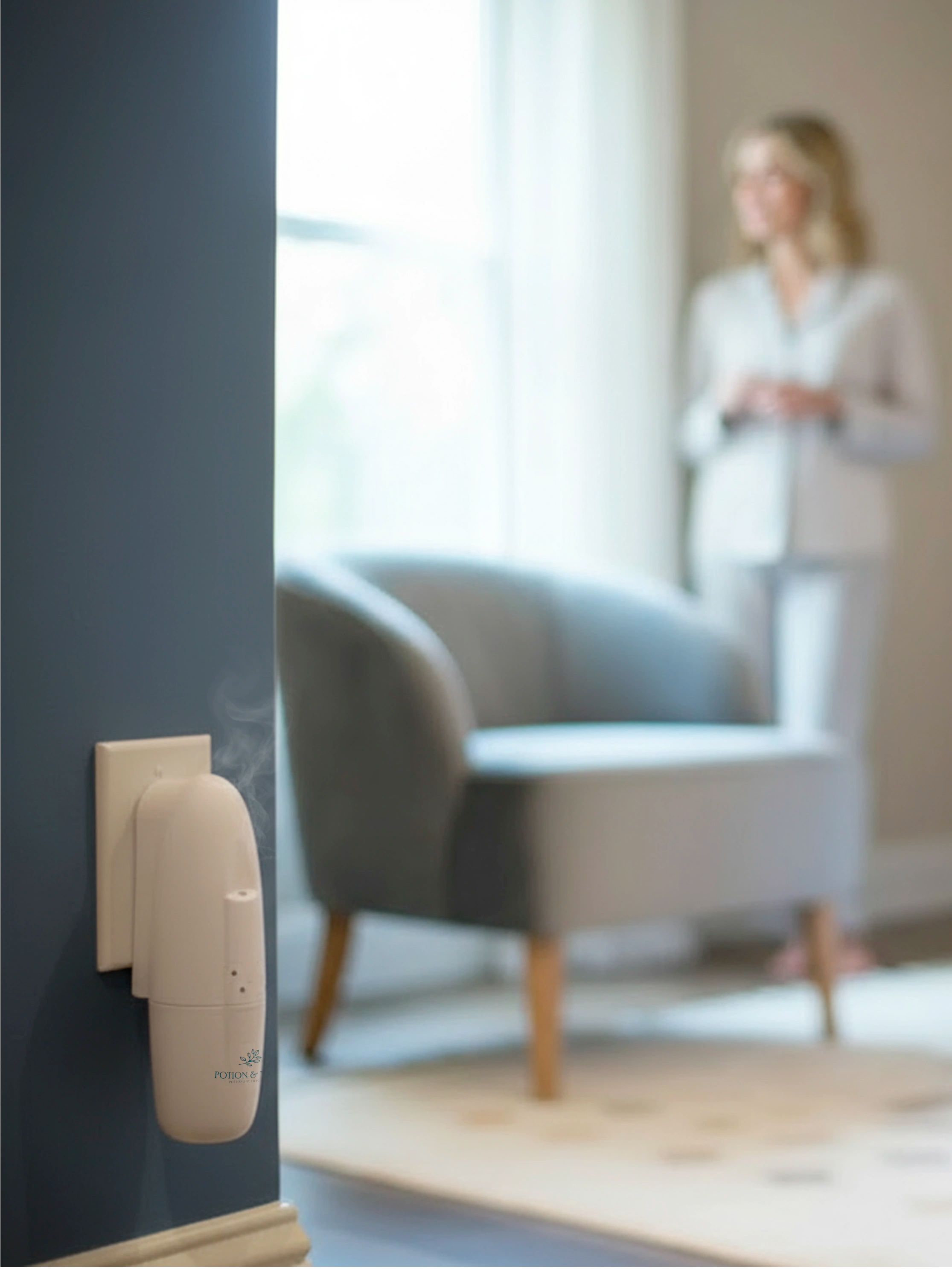 Wall-mounted "Sienna" scent diffuser with a blurred background of a living room.