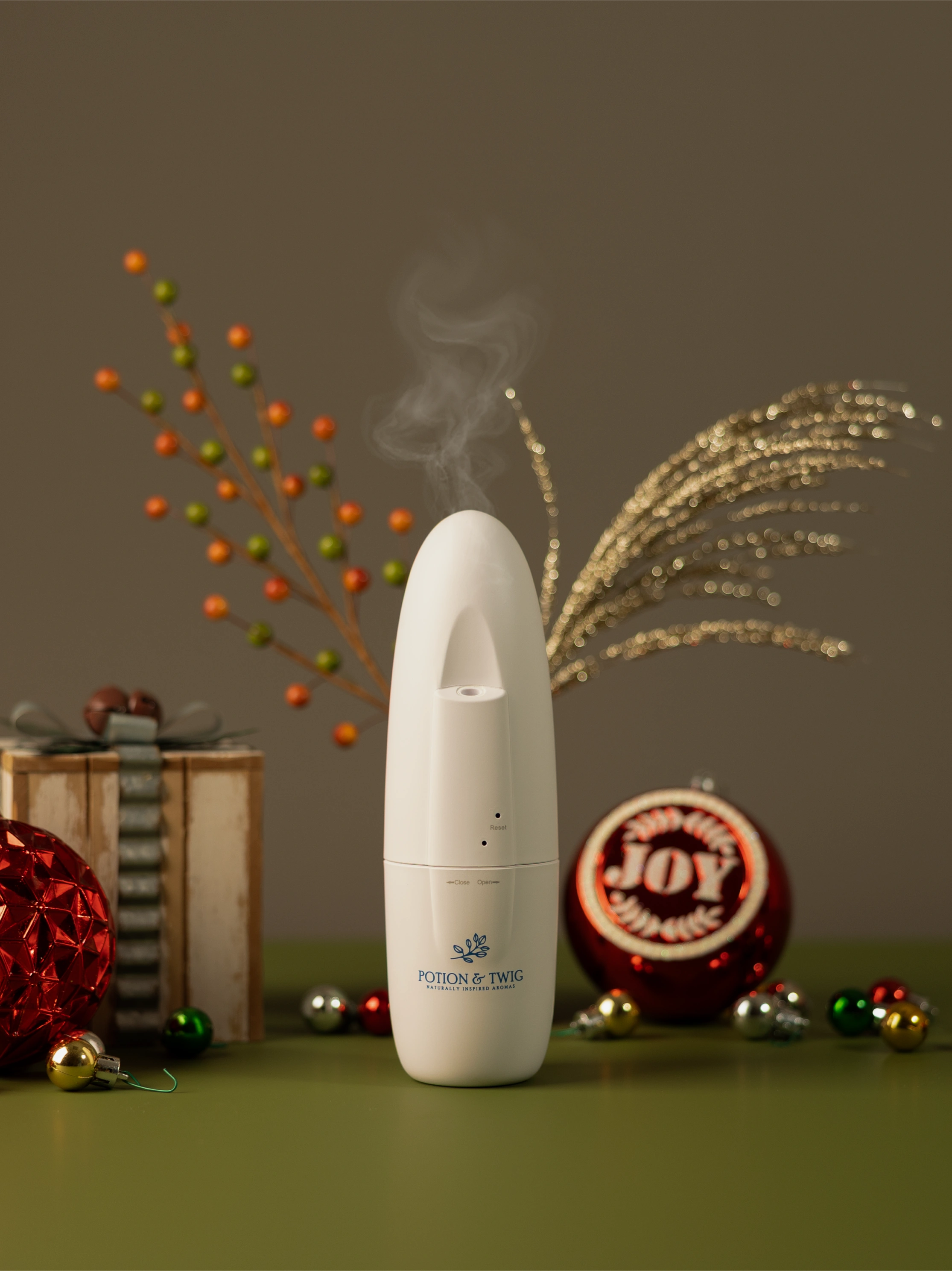 White Sienna Fragrance diffuser with holiday decorations around it.