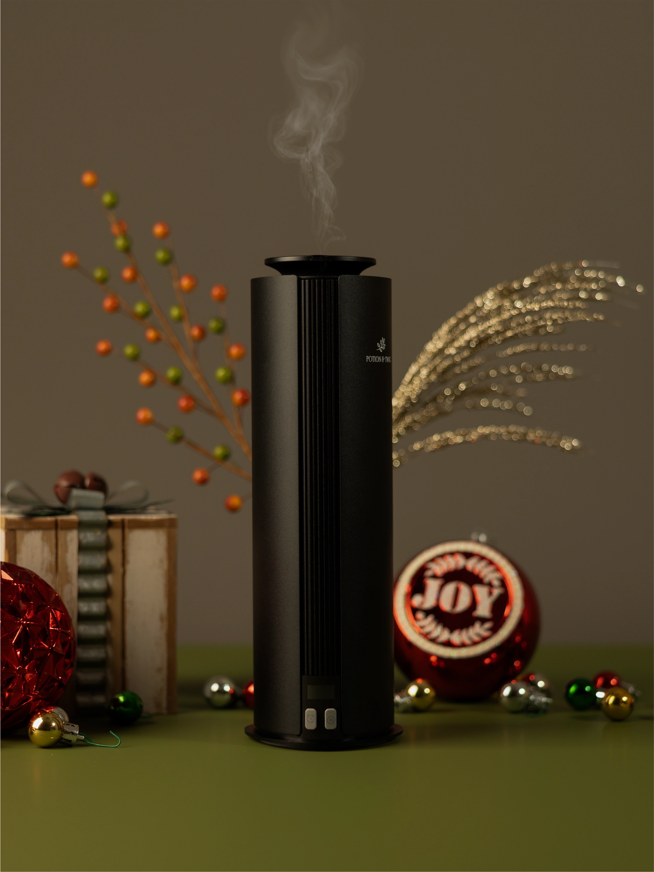 Black Spire Fragrance diffuser with holiday decorations around it.