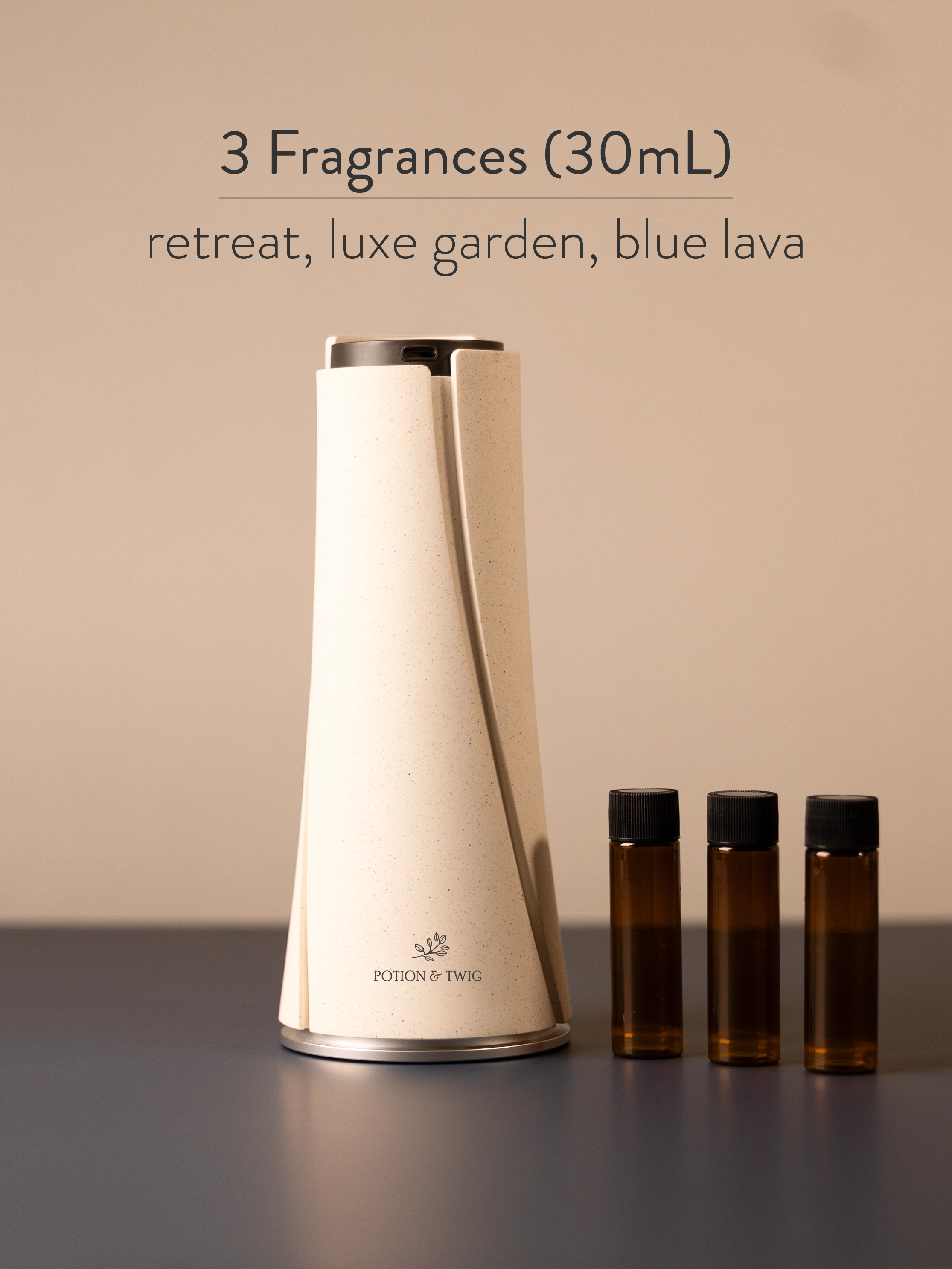 White diffuser with three small brown bottles labeled 'retreat', 'luxe garden', and 'blue lava' on a neutral background.