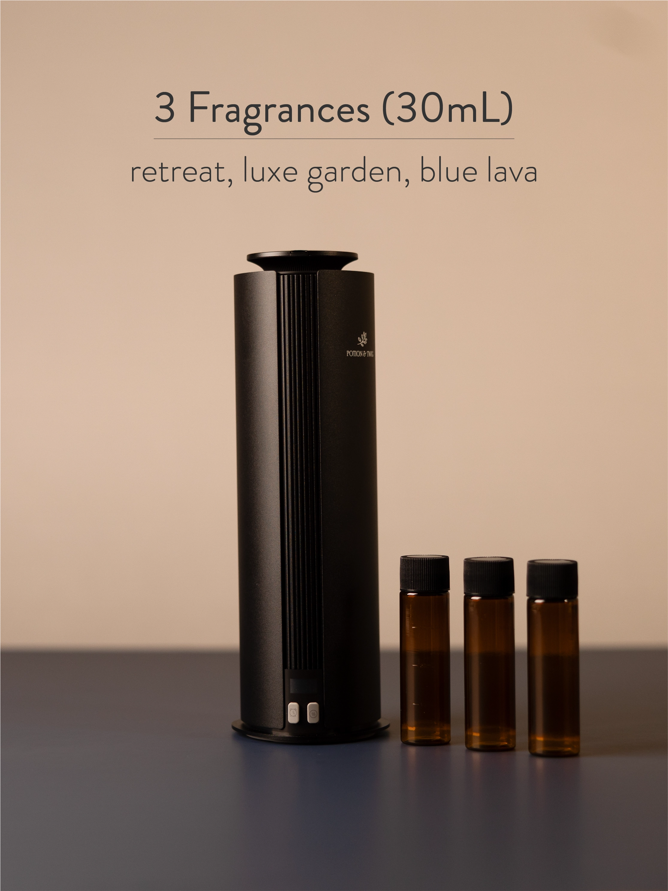 Black diffuser with three small brown bottles labeled 'retreat', 'luxe garden', and 'blue lava' on a neutral background.