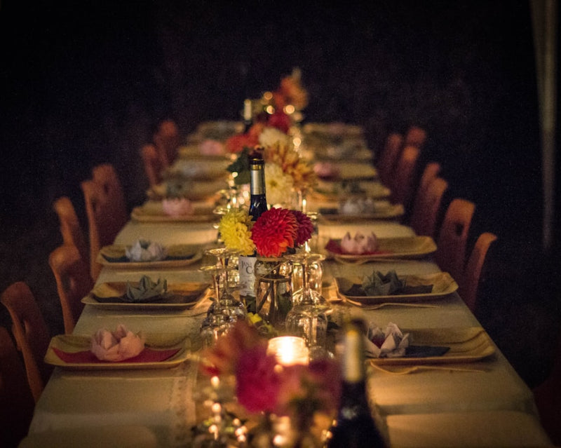 long luxury dinner table candle lit with many place settings