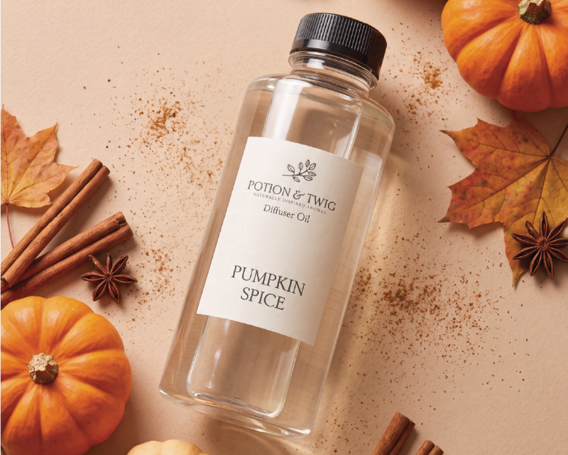Pumpkin Spice Diffuser fragrance bottle from Potion & Twig laying on a light background surrounded by pumpkins leaves and cinnamon