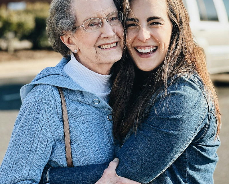 elderly woman and a young woman hugging each other and smiling