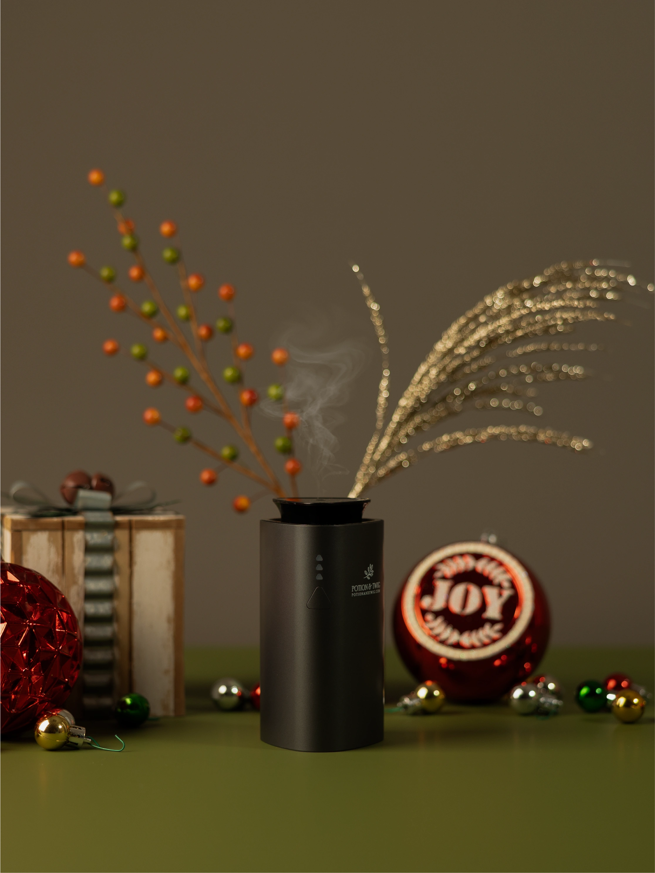 Black Companion Fragrance diffuser with holiday decorations around it.