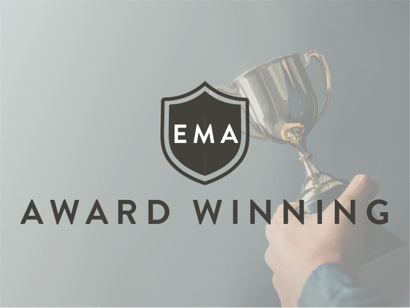 Hand holding a trophy with EMA logo and 'Award Winning' text on a gray background
