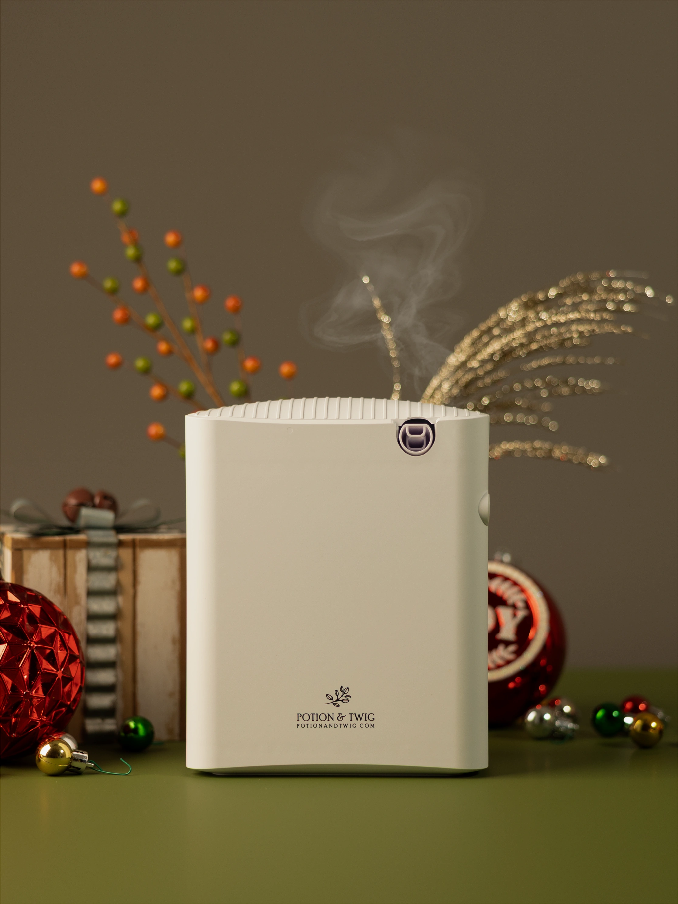 White Gallery Fragrance diffuser with holiday decorations around it.