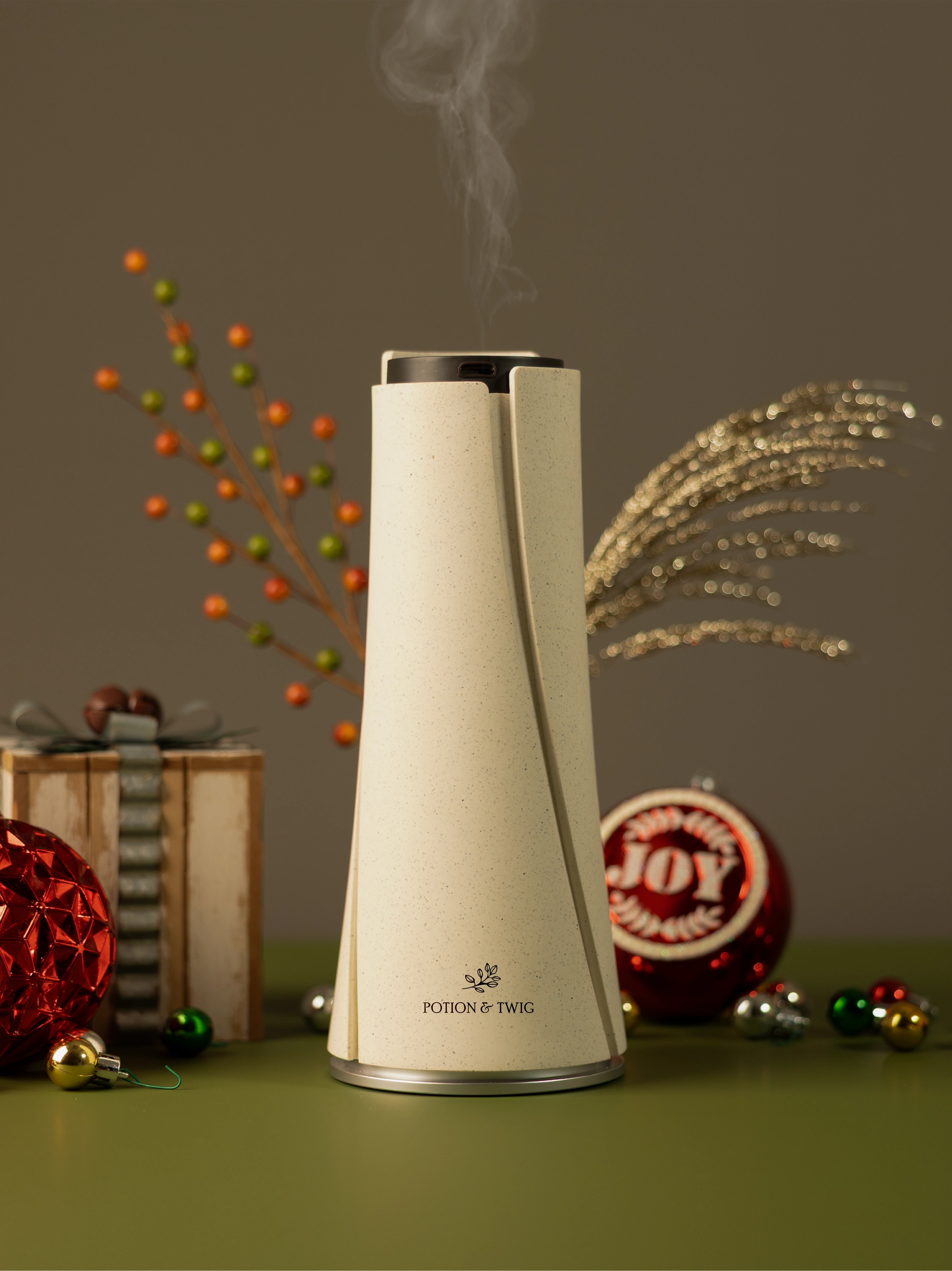 White Lumen Fragrance diffuser with holiday decorations around it.