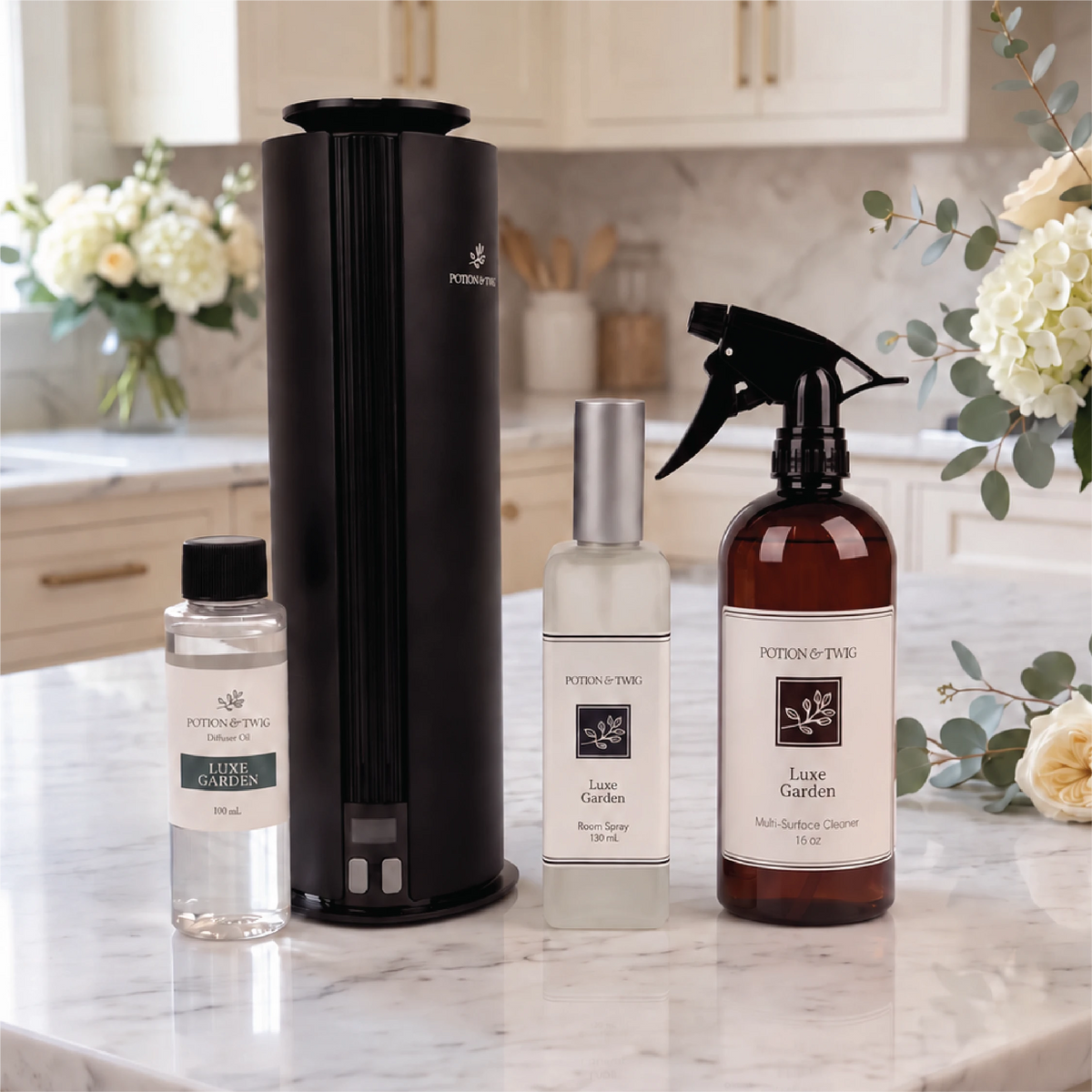 Four Potion & Twig products, featuring a Luxe Garden 16 oz Multi-Surface cleaner, Luxe Garden 130mL room spray, a spire diffuser with a Luxe Garden 100mL oil bottle sitting on a countertop in a kitchen.