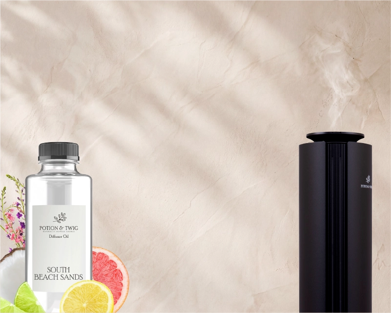 Black Spire Scent diffuser and a fragrance oil bottle of "South Beach Sands" with a light colored textured wall,