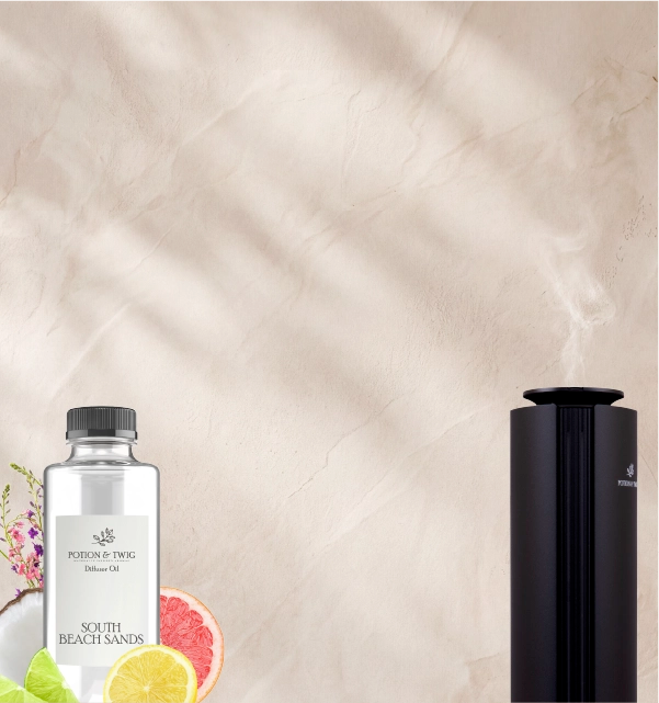 Black Spire Scent diffuser and a fragrance oil bottle of "South Beach Sands" with a light colored textured wall,