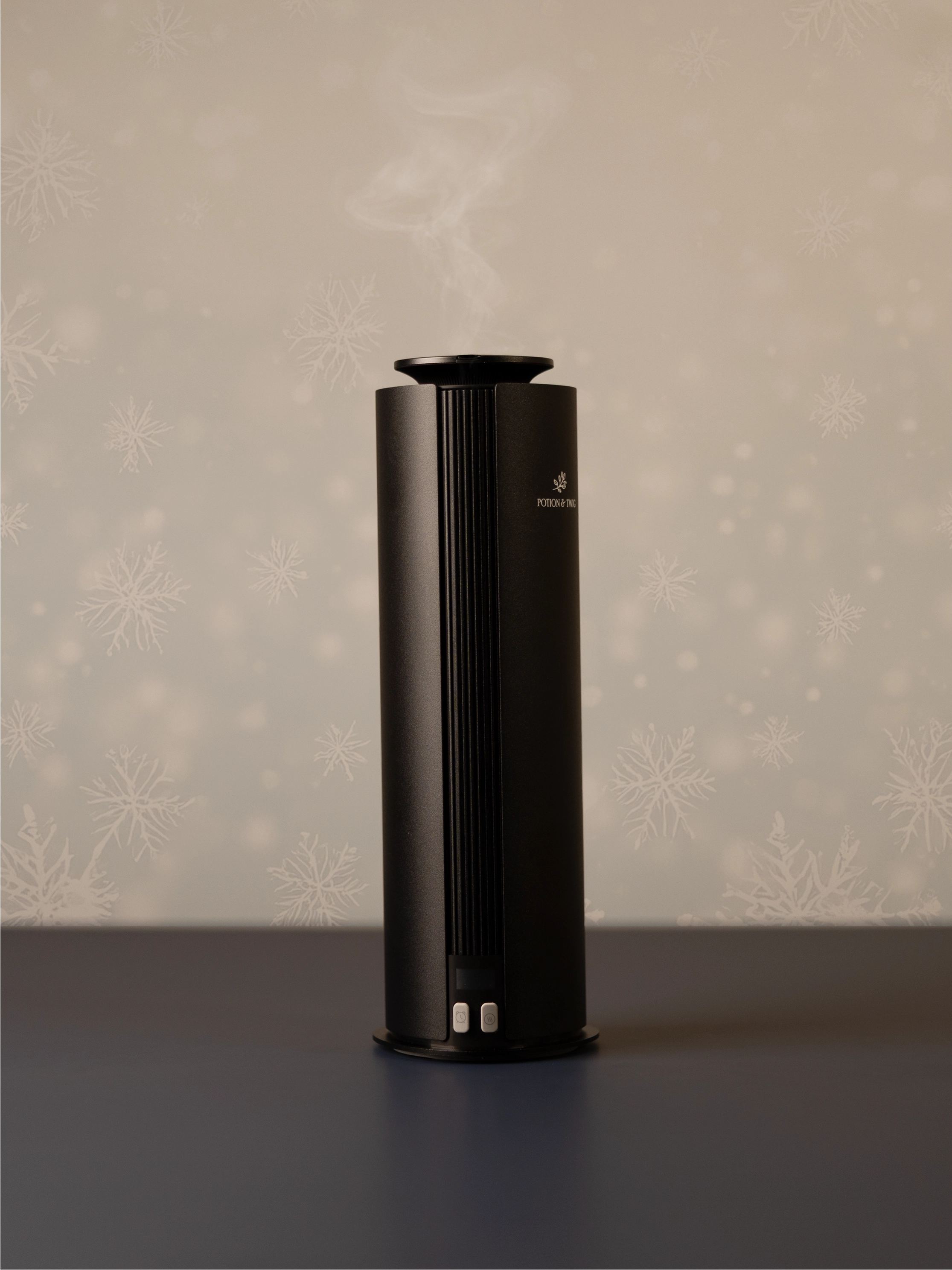 Black cylindrical scent diffuser on light neutral background