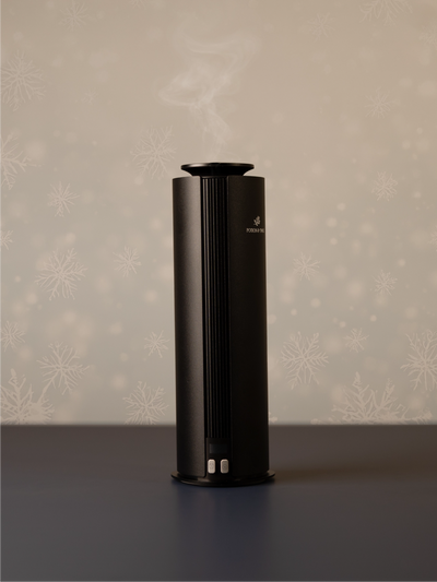 Black cylindrical scent diffuser on light neutral background