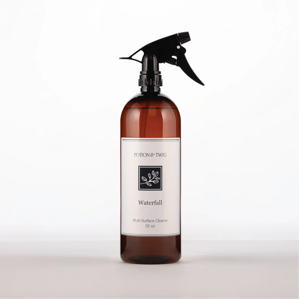 Brown spray bottle with 'Potion & Twig' brand label. On a white background. Labeled Waterfall Multi-Surface Cleaner
