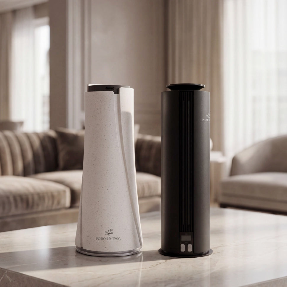 Two cylindrical scent diffusers branded with "Potion & Twig" on a marble surface with a blurred living room background