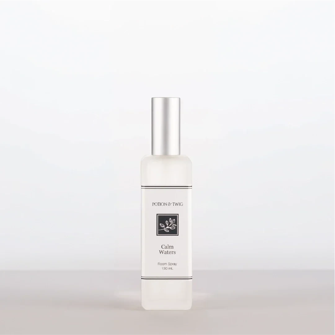 Luxury Room Spray in a clear cylindrical bottle with a silver cap, cream label and Calm Waters fragrance.