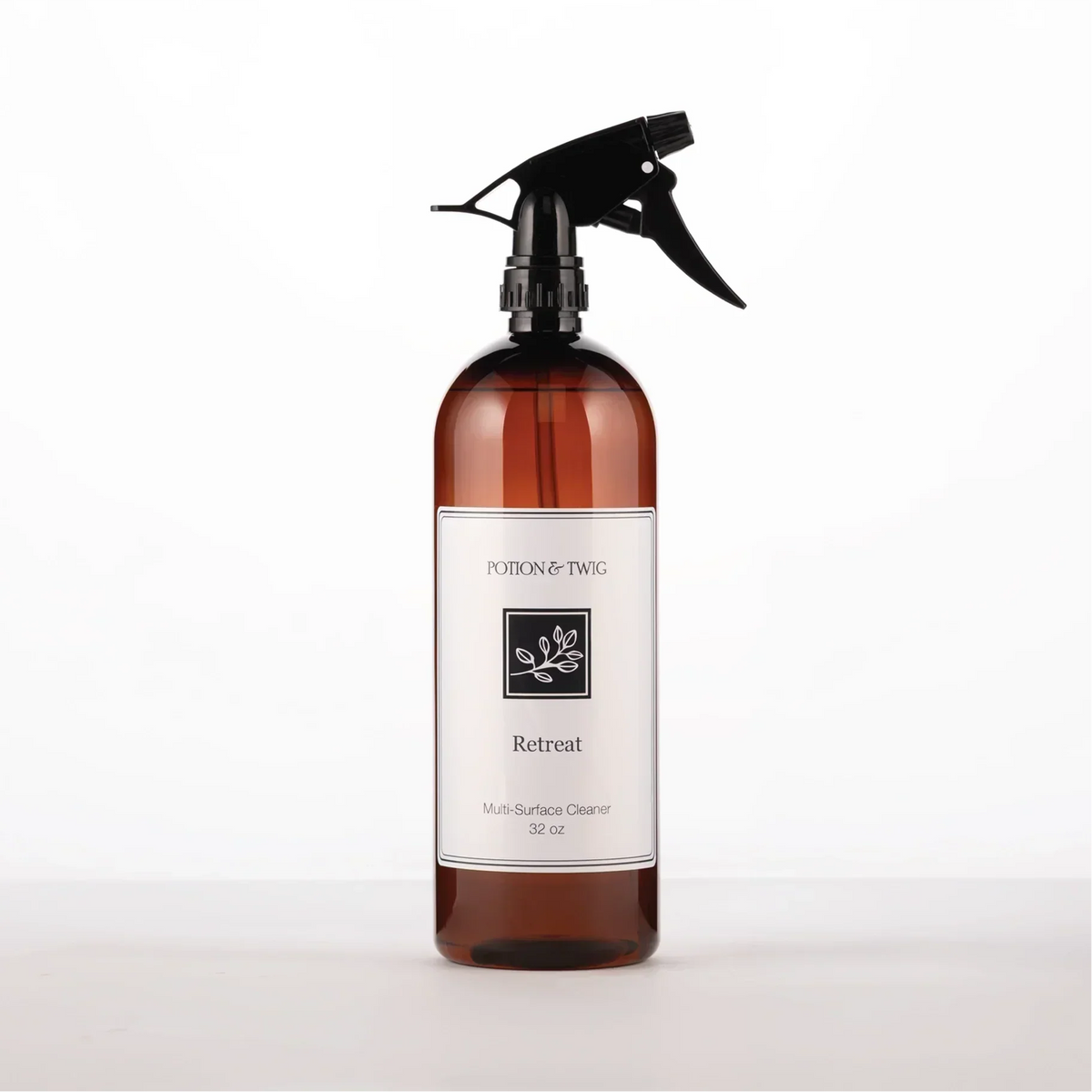 Luxury Surface Cleaner in a translucent amber glass spray bottle with a black trigger and white botanical label