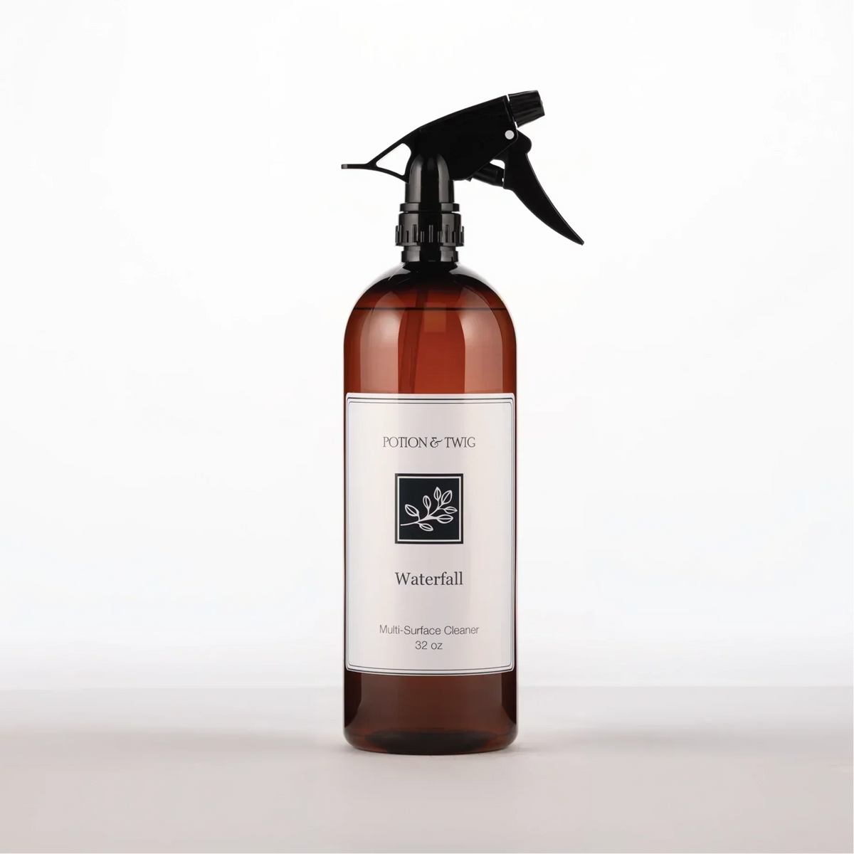 Luxury Surface Cleaner in an amber bottle with a black trigger spray and a white Waterfall multi-surface cleaner label