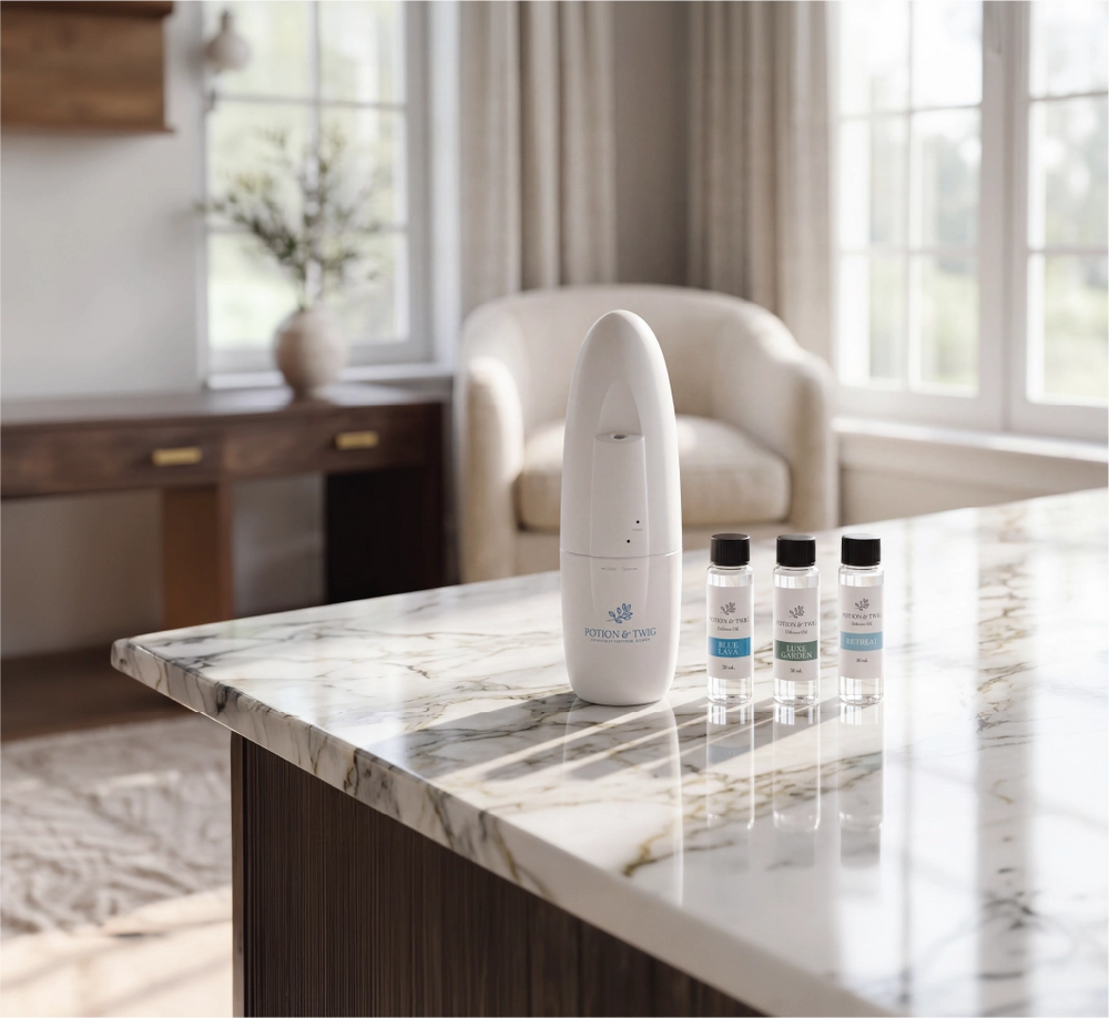 White diffuser on a marble countertop with oil bottles in a bright room.